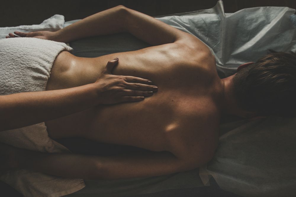 Zbliżenie na męskie plecy podczas relaksującego masażu prostaty
